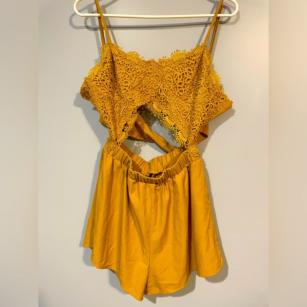 Mustard romper with lace detailing, cutouts and bow on back